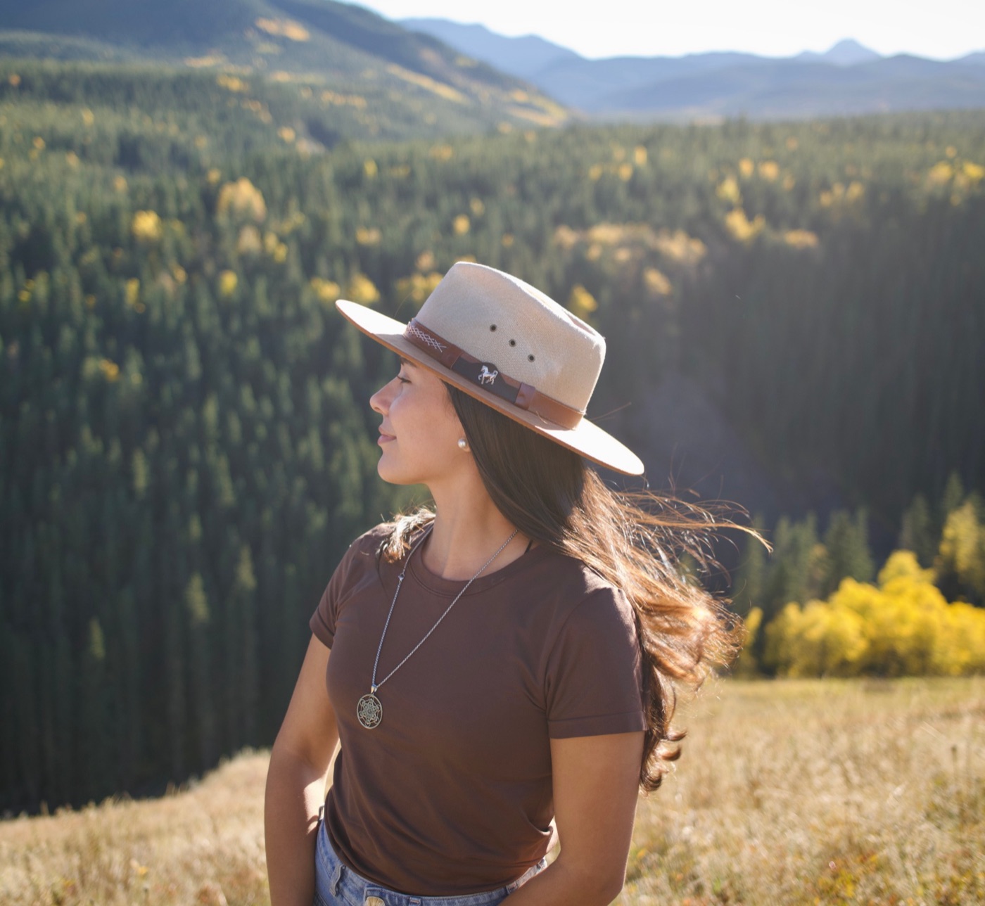 Maca Salvo looking out over a forest and mountains in autumn